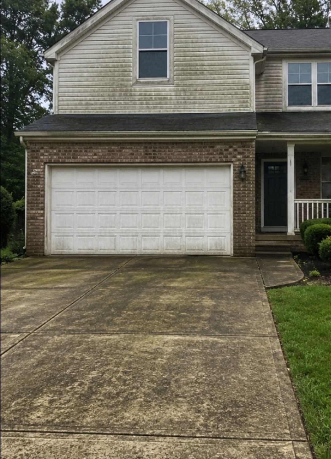 House siding and driveway before pressure washing